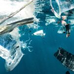 Lixo e fragmentos de plástico flutuando no oceano, origem dos microplásticos